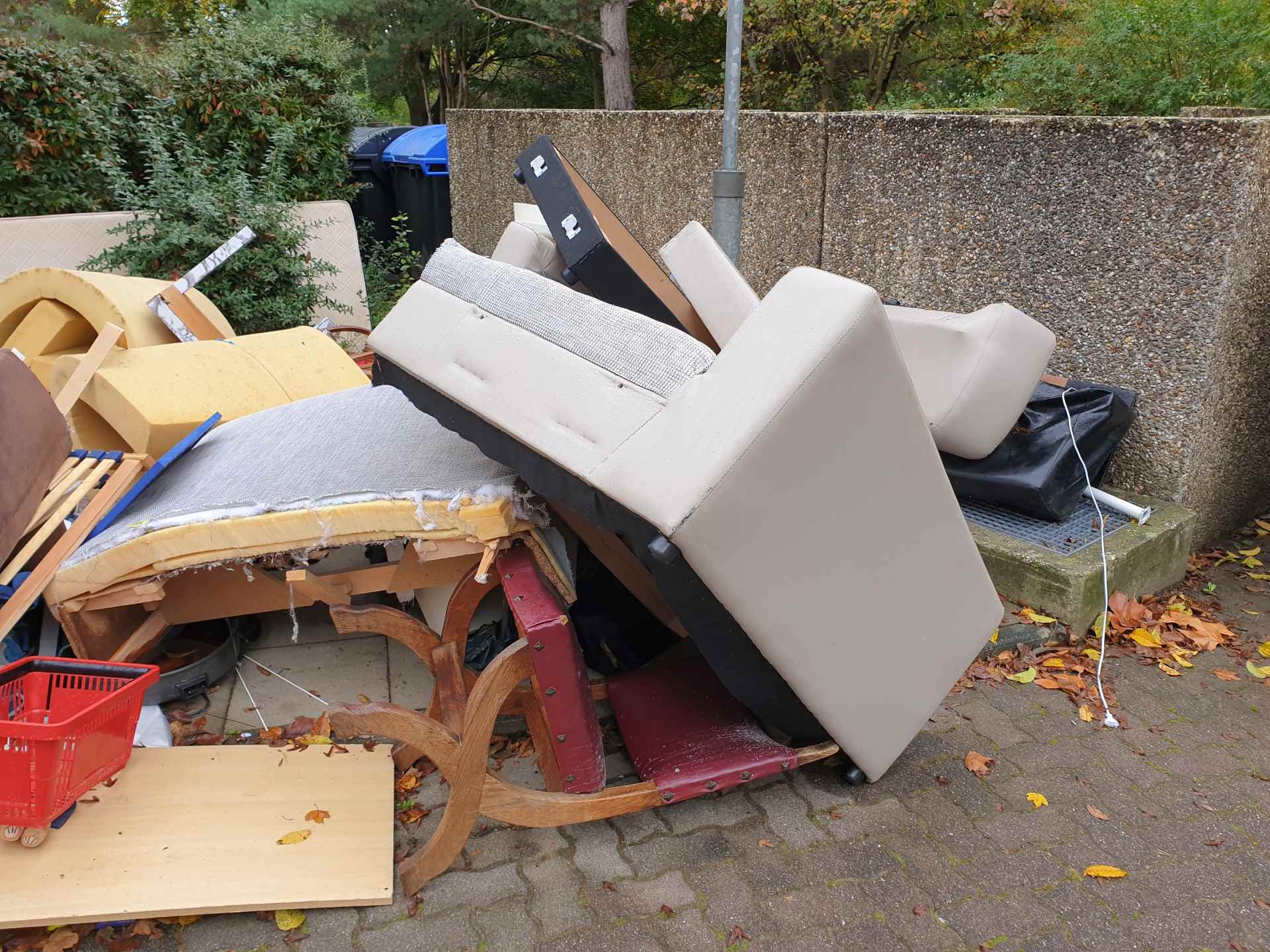 Old furniture and junk piled on pavement.