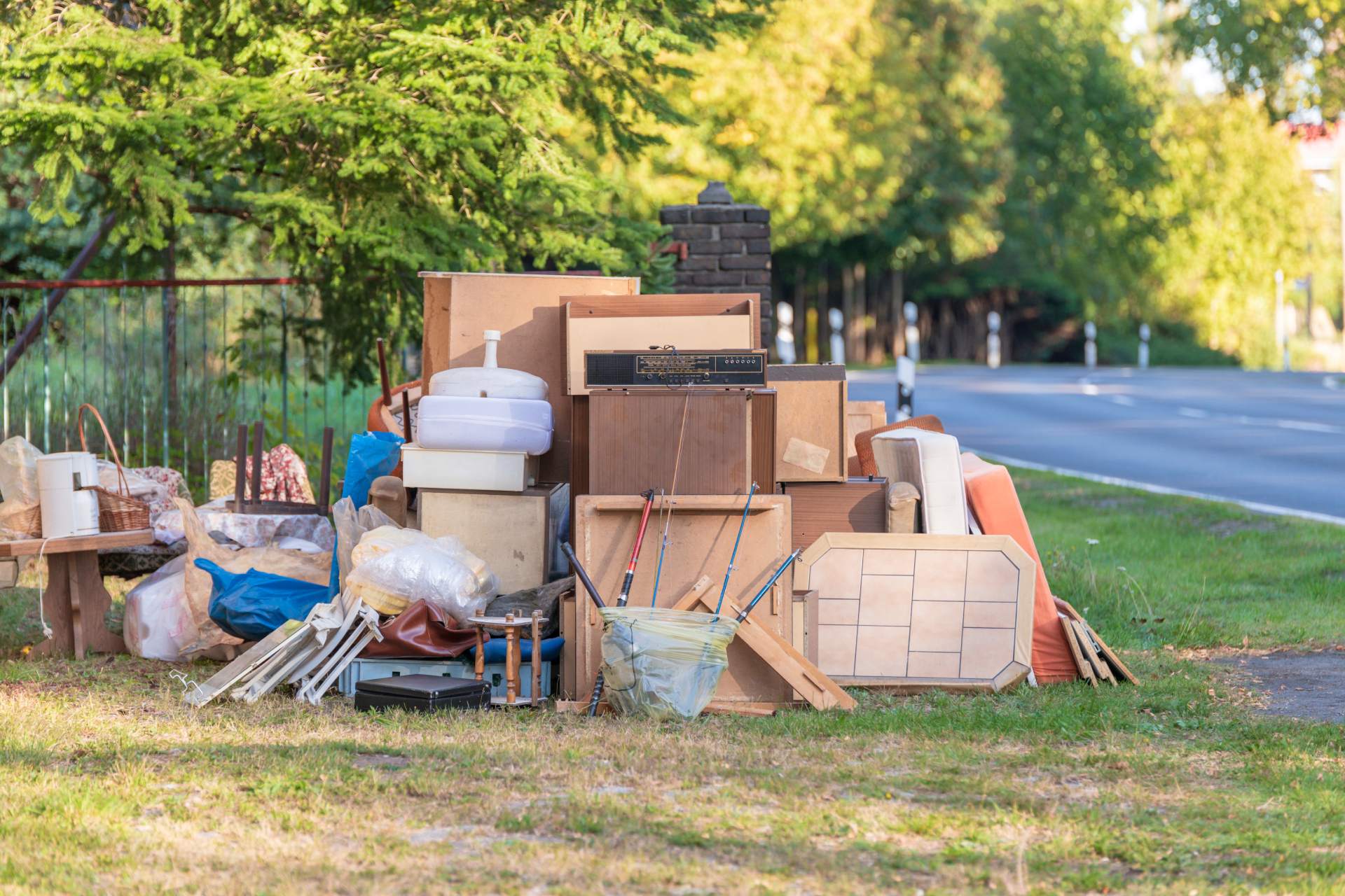 Abandoned wooden furniture and household items outside.