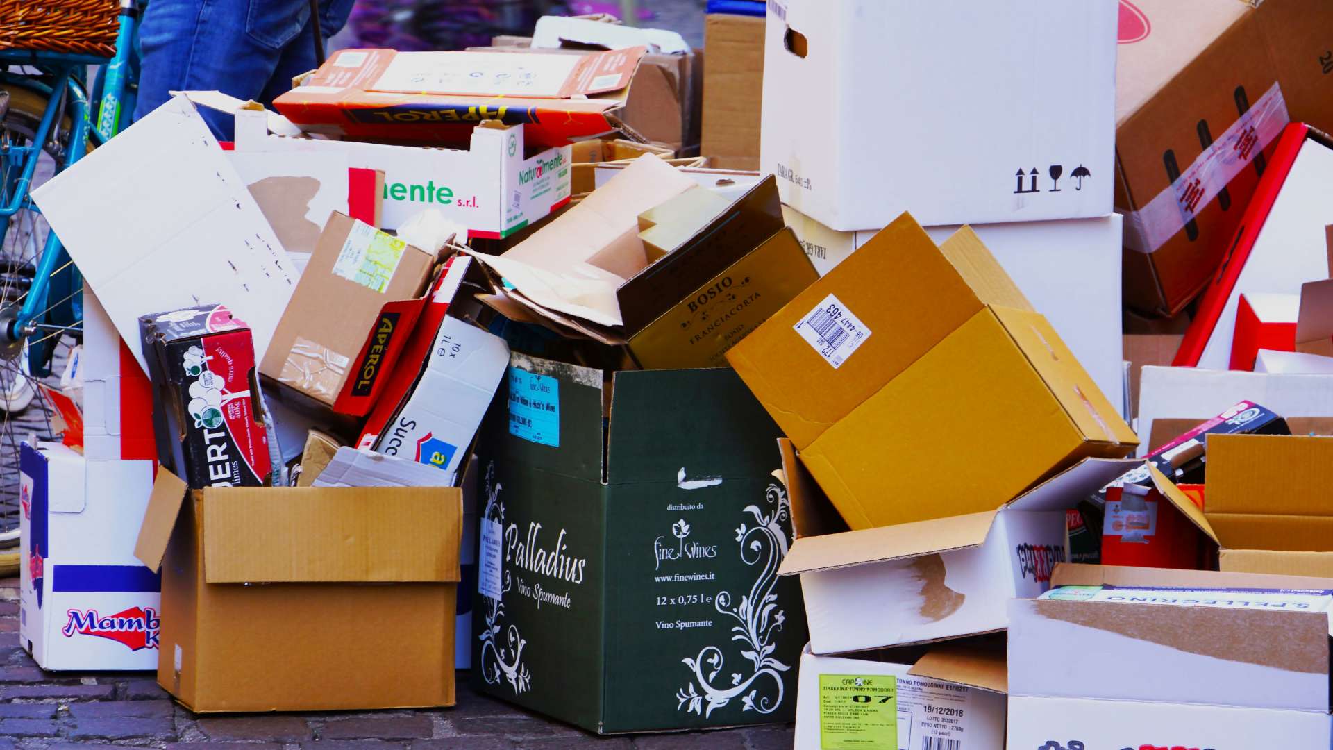 Pile of empty boxes stacked on pavement.